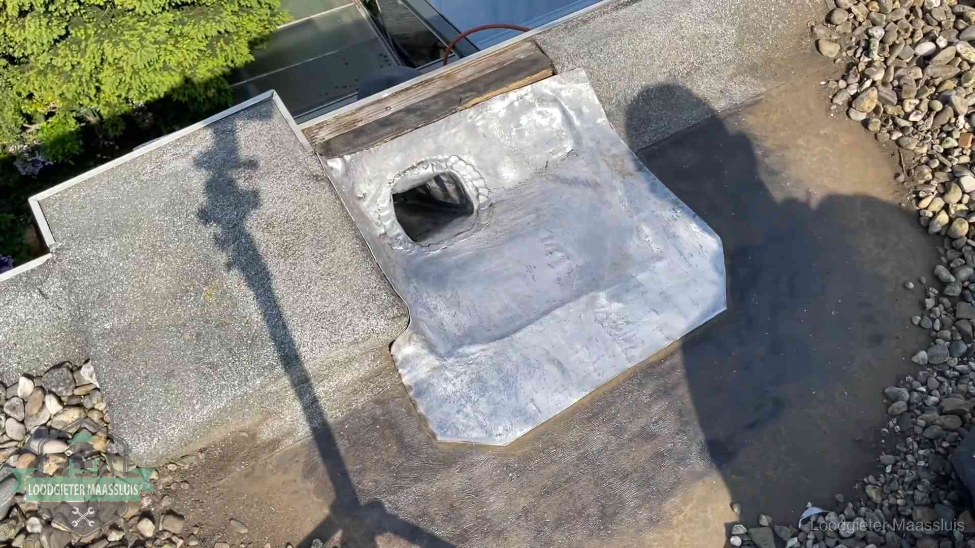 Noodafdichting bij daklekkage in Maassluis Vers afgedichte dakdoorvoer met lood en zink op een plat dak in Maassluis