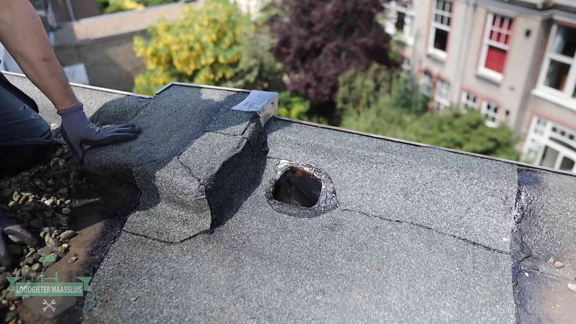 Daklekkage-inspectie op een plat dak in Maassluis Loodgieter inspecteert een beschadigd bitumen plat dak tijdens een daklekkage-inspectie in Maassluis