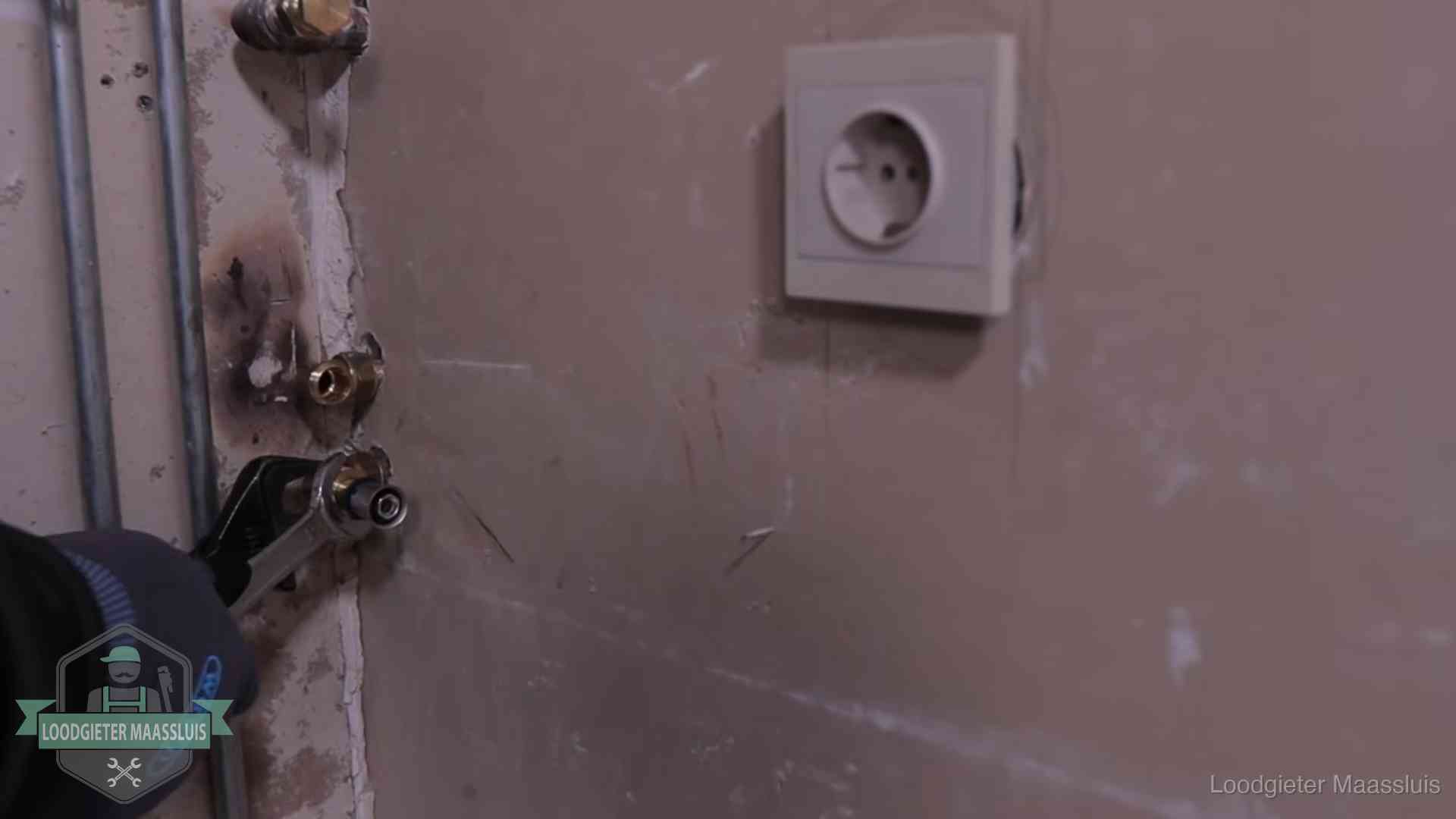 Monteur draait een perskoppeling vast op een leidingaansluiting in Maassluis