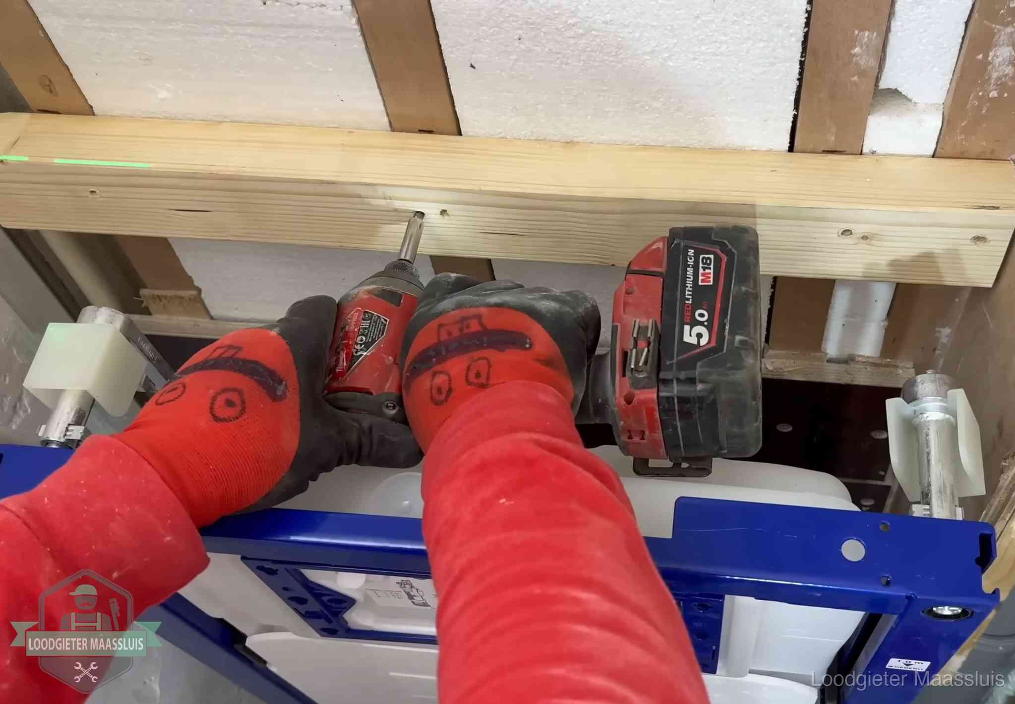 Monteur bevestigt een inbouwreservoir voor een hangend toilet in Maassluis