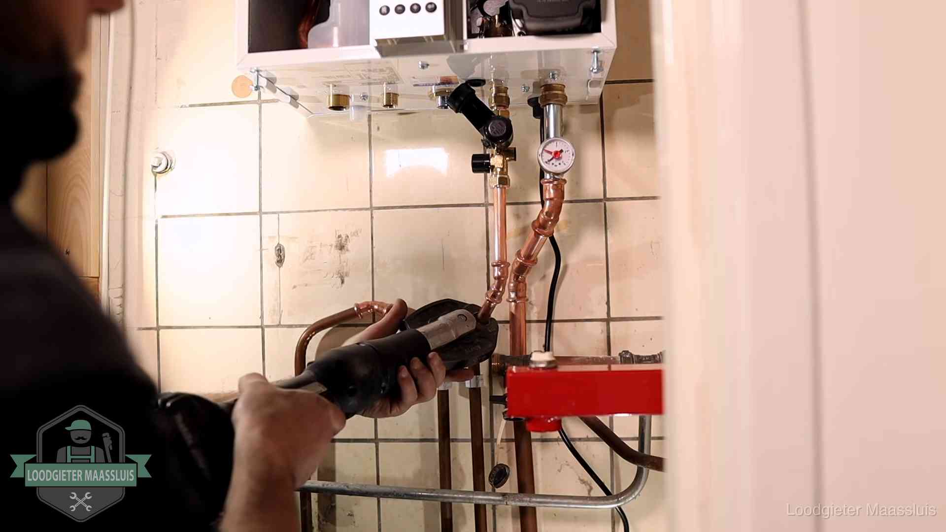 Cv-ketel onderhoud in Maassluis Monteur werkt aan de leidingen onder een cv-ketel in Maassluis