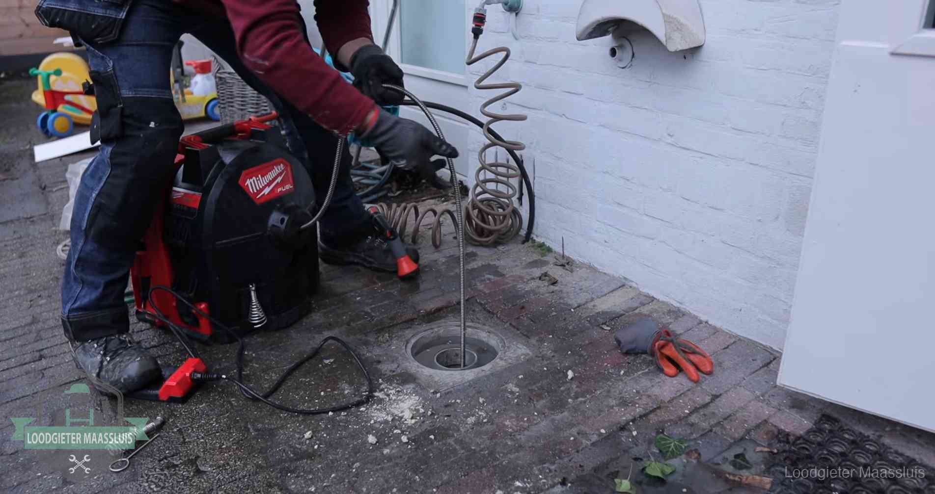 Erfgrens en gemeenteriool in Maassluis Ontstoppingsputje in de bestrating naast de gevel van een woning in Maassluis