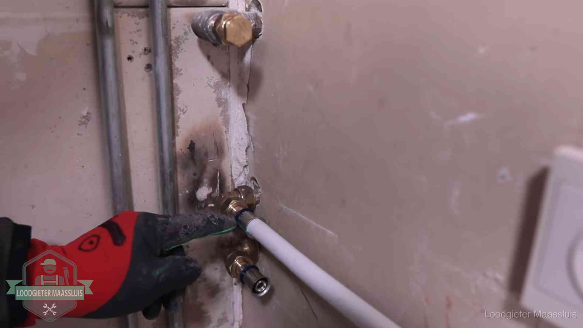 Loodgieter wijst de persfitting op nieuwe muuraansluitingen aan in een woning in Maassluis