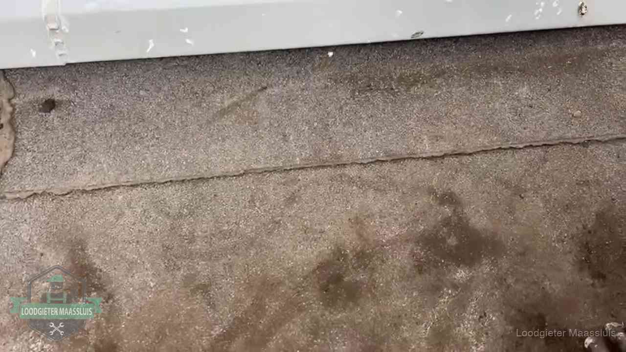 Stormschade en neerslag op daken in Maassluis Vochtplekken bij de naad van een plat dak na aanhoudende regen in Maassluis