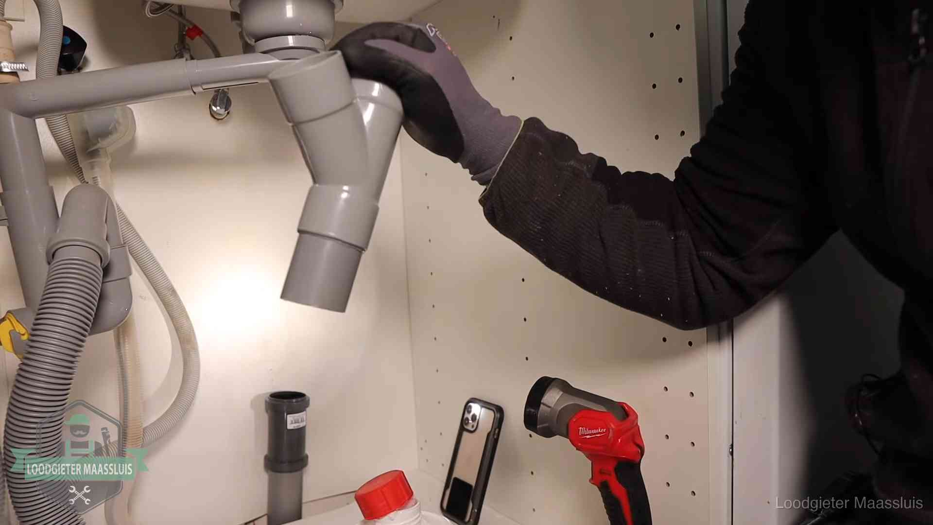 Rioollucht in huis verhelpen in Maassluis Loodgieter demonteert het sifon- en afvoerwerk onder een gootsteen in Maassluis bij stankklachten