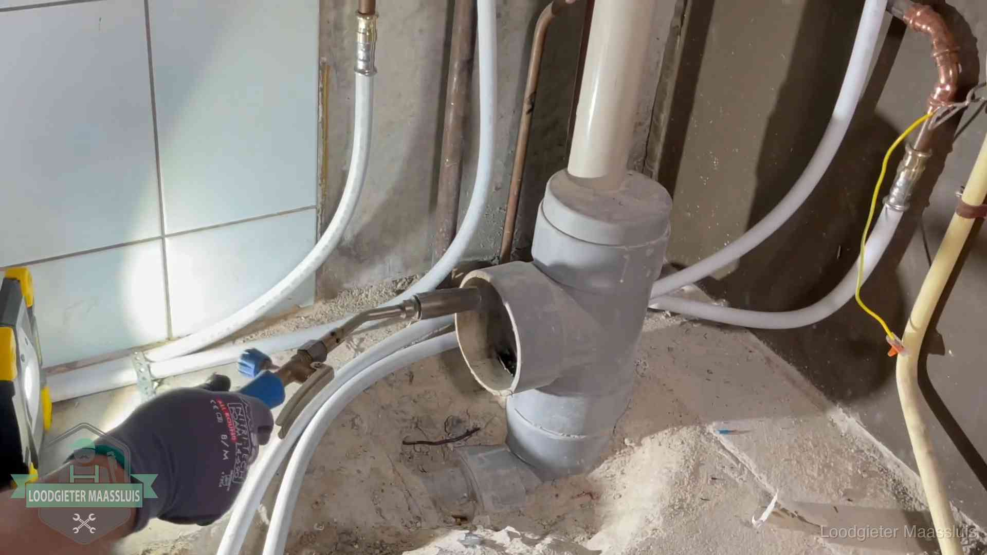 Verstopping in een huurwoning in Maassluis Loodgieter werkt aan leidingen bij de pvc-standleiding van een huurwoning in Maassluis