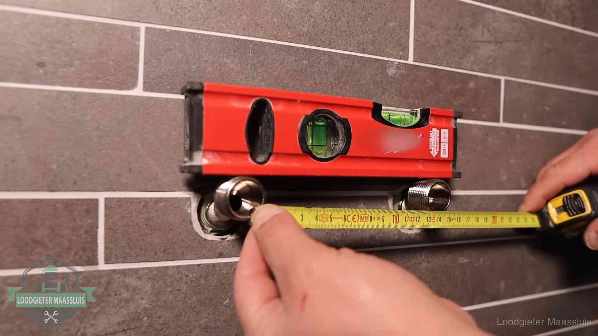Waterpas en duimstok bij kraan-aansluitpunten in een badkamer in Maassluis