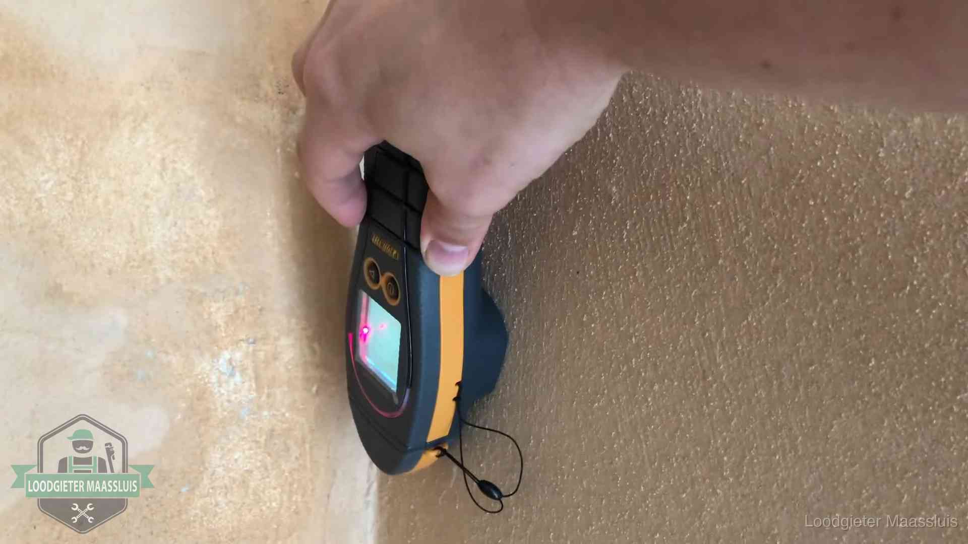 Daklekkage opsporen zonder hakwerk in Maassluis Vochtmeter tegen een muur met vochtplekken tijdens het opsporen van een daklekkage in Maassluis