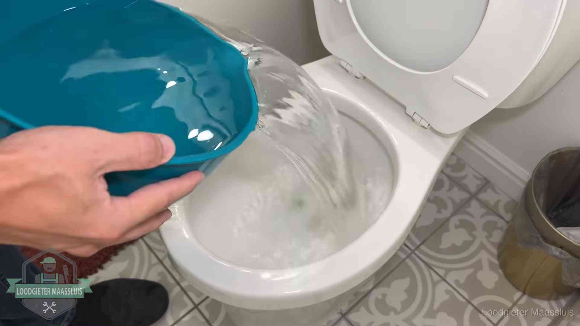 Warm water wordt voorzichtig in de wc-pot gegoten in Maassluis