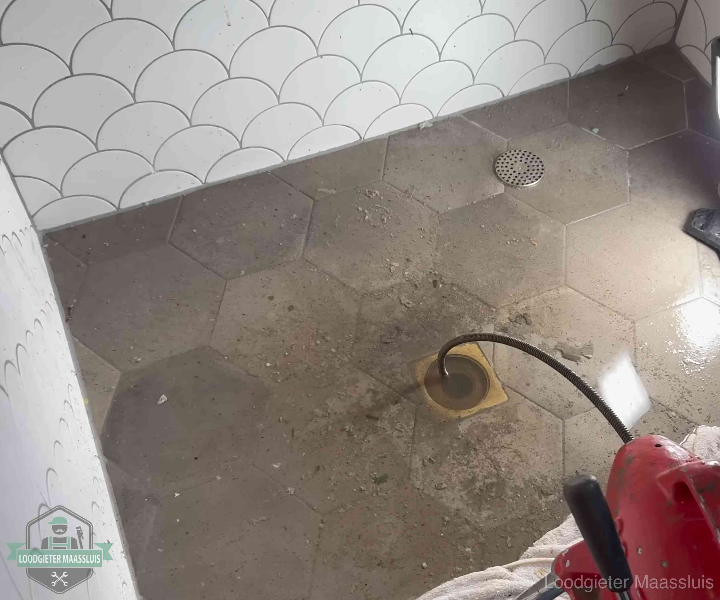 Vloerput met waterslot in een badkamer in Maassluis, een bron van stank als het waterslot droogstaat