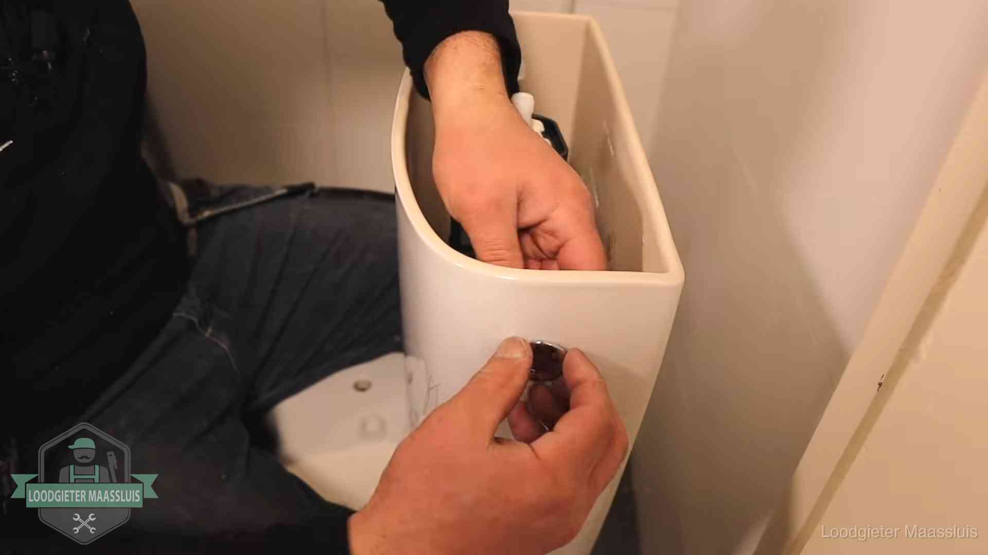 Drukknop van een duoblok-stortbak wordt gemonteerd bij een toilet in Maassluis