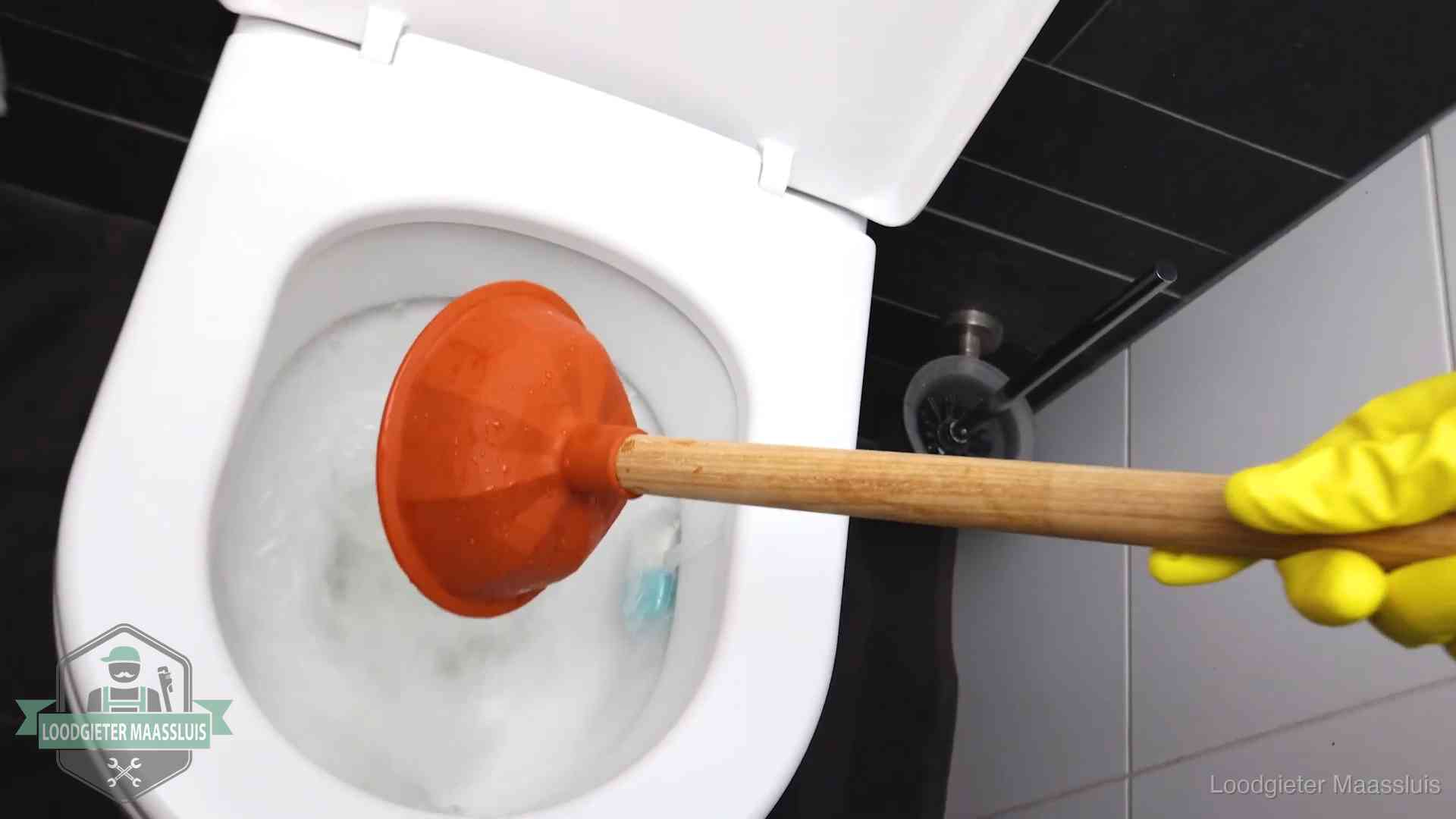 Plopper wordt in de wc-pot gedrukt bij het ontstoppen van een toilet in Maassluis